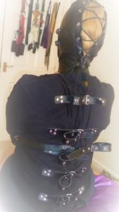 Straitjacket on a submissive with BDSM flails in background